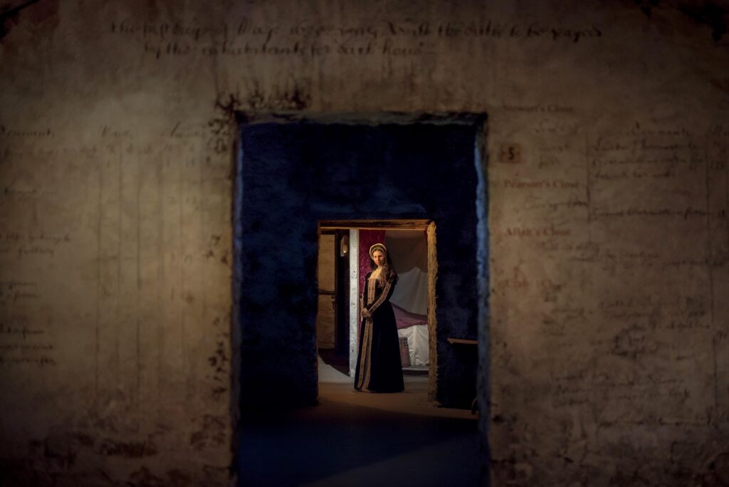 One of our guides dressed as Mary Queen of Scots stands in a room on our site and can be seen through the doorway