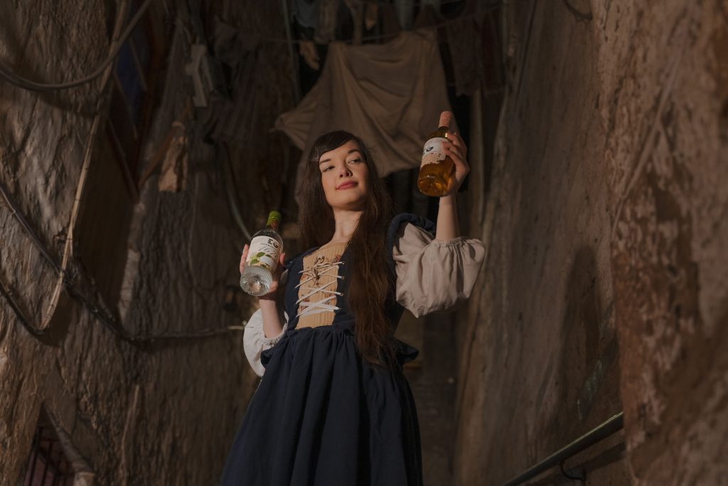 Tour guide holding gin bottles. Our Tour and Gin Tasting experiences are one of the best things to do in Edinburgh in July 2022. 