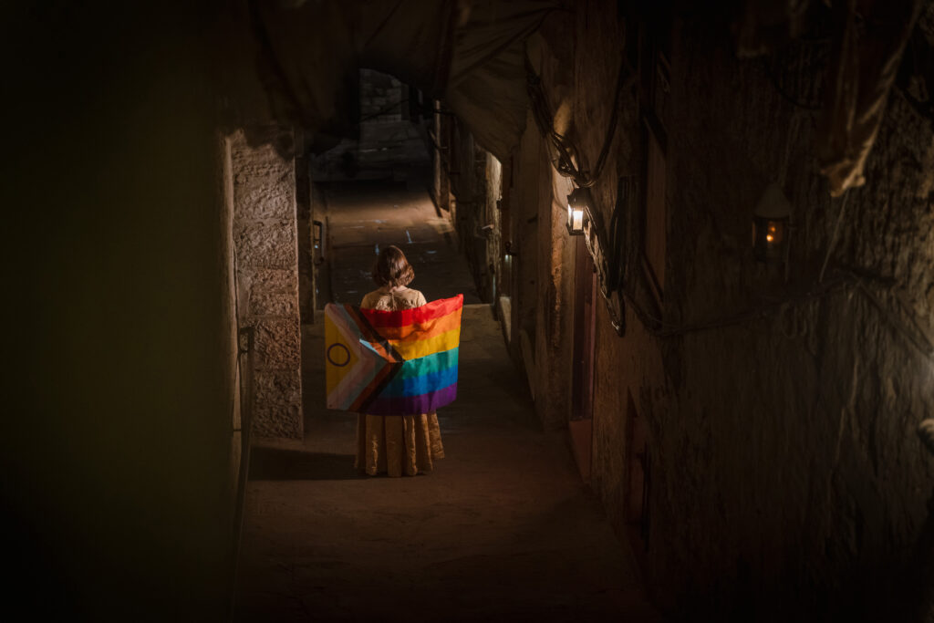 A guide holds up a Pride flag on Mary King's Close