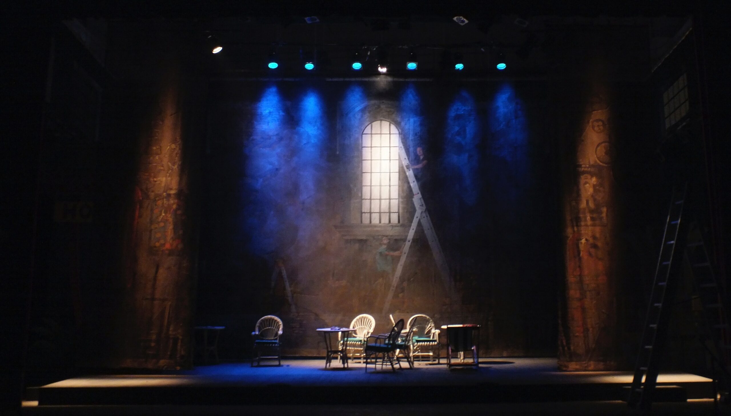 Image of an empty stage with chairs and ladders. 